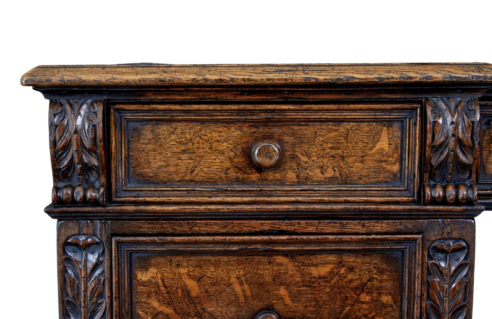 A late nineteenth-century Victorian dark carved oak pedestal desk featuring a leather writing surface, multiple drawers, and turned legs on stretcher bases. View VIII