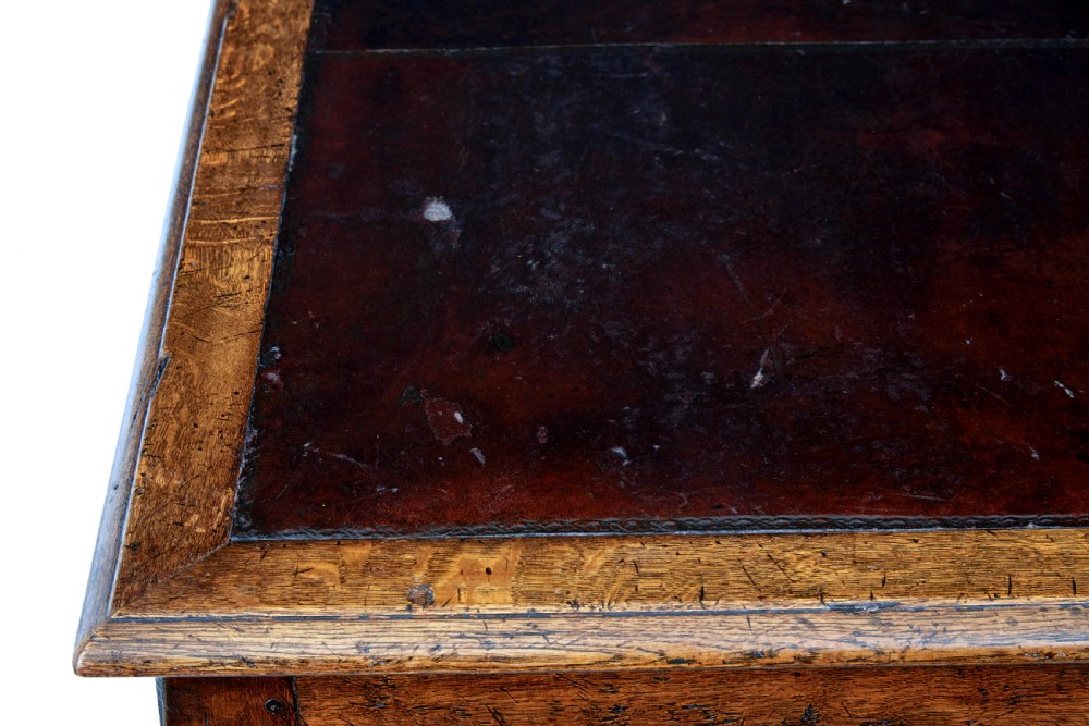 A late nineteenth-century Victorian dark carved oak pedestal desk featuring a leather writing surface, multiple drawers, and turned legs on stretcher bases. View XI