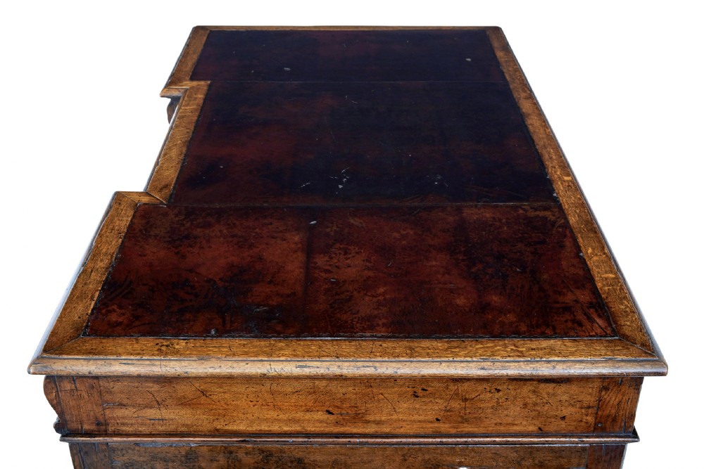 A late nineteenth-century Victorian dark carved oak pedestal desk featuring a leather writing surface, multiple drawers, and turned legs on stretcher bases. View XII