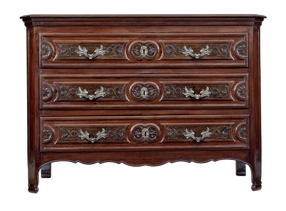 A 19th-century French Provincial walnut commode featuring three long carved drawers with brass handles and a scalloped lower apron. View II