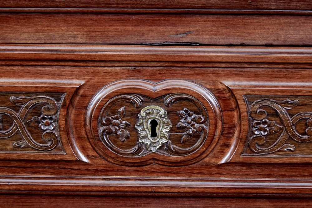 A 19th-century French Provincial walnut commode featuring three long carved drawers with brass handles and a scalloped lower apron. View IX