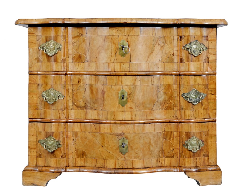 An 18th-century burr walnut serpentine-front chest of drawers featuring three long drawers with ornate brass handles and bracket feet. View II