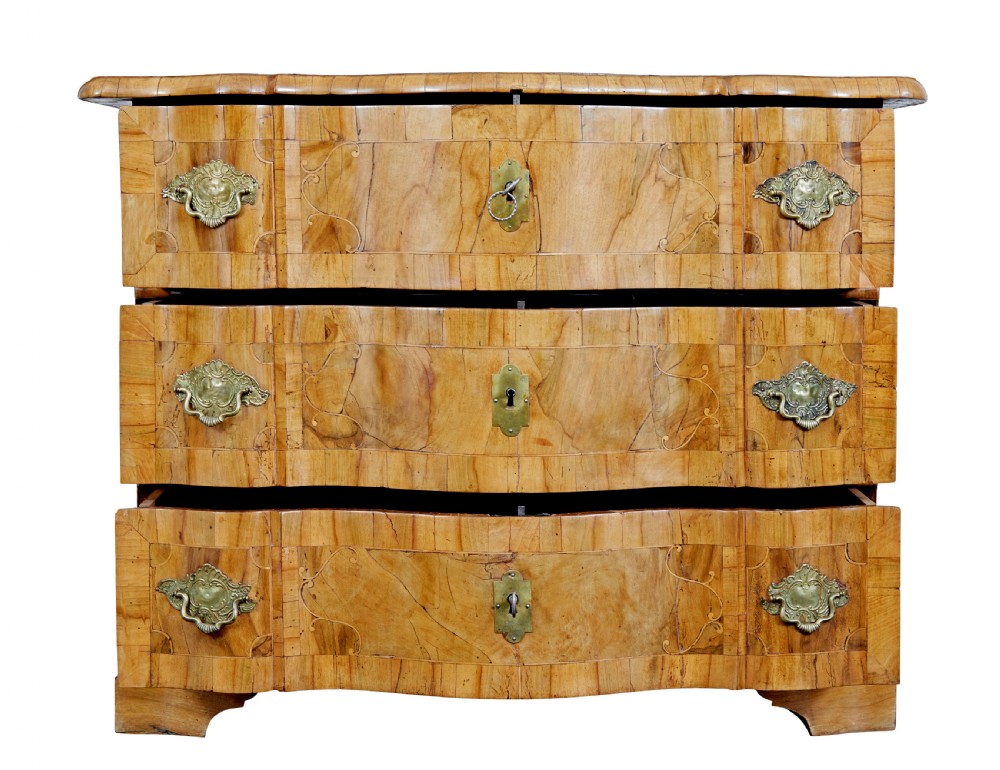 An 18th-century burr walnut serpentine-front chest of drawers featuring three long drawers with ornate brass handles and bracket feet. View III