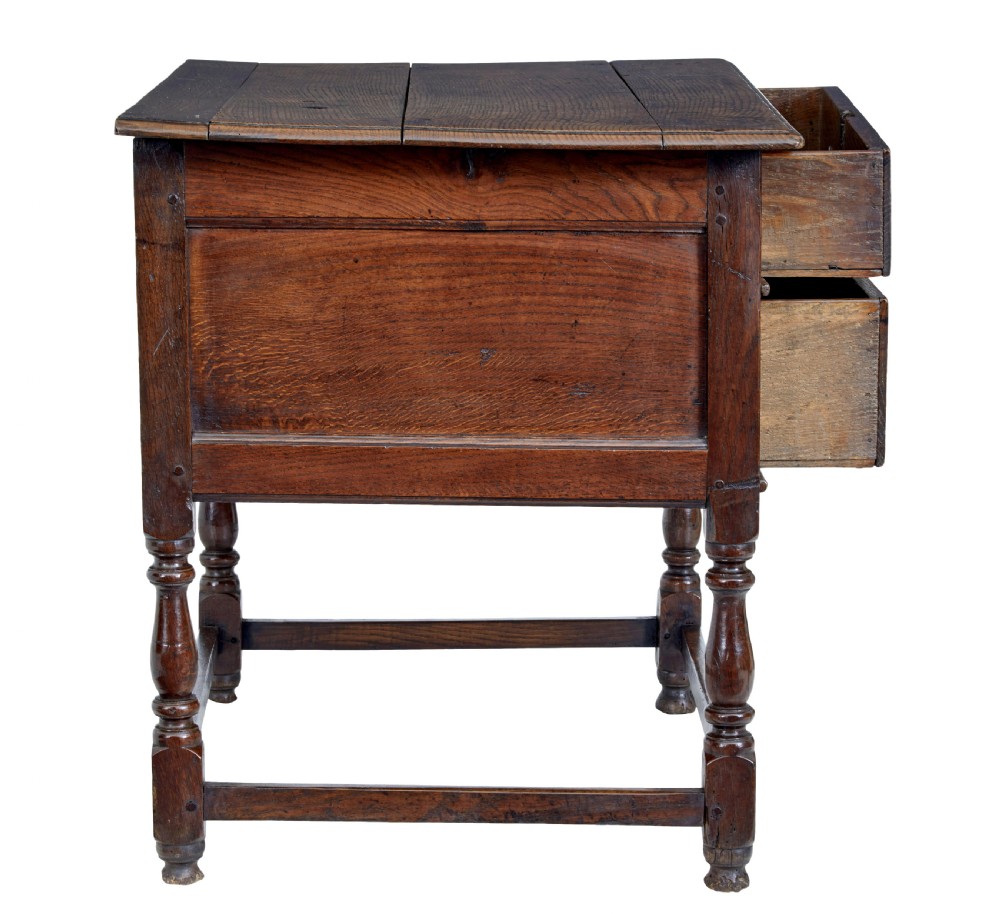 An early 18th-century Georgian oak side table featuring two drawers with brass drop handles, keyhole escutcheons, turned legs, and a box stretcher. View VII