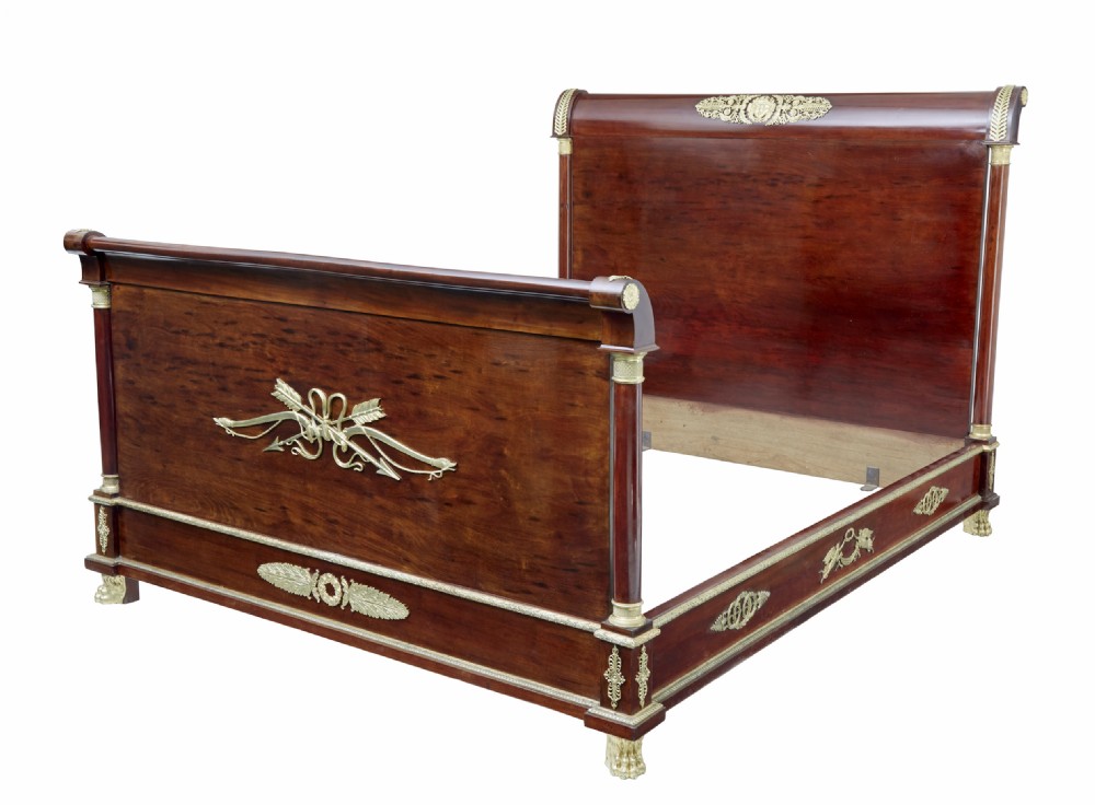 A five-piece nineteenth-century French Empire Revival mahogany bedroom suite featuring gilt bronze mounts, including a sleigh bed, a three-door mirrored wardrobe, a dressing table with mirror, and two matching bedside cabinets. View III