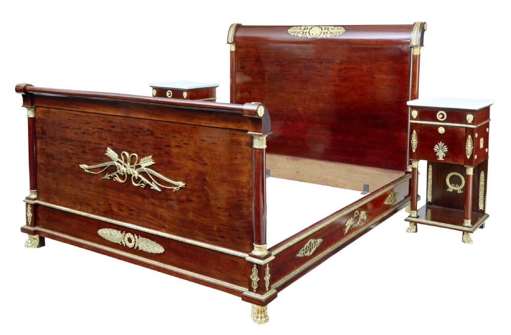 A five-piece nineteenth-century French Empire Revival mahogany bedroom suite featuring gilt bronze mounts, including a sleigh bed, a three-door mirrored wardrobe, a dressing table with mirror, and two matching bedside cabinets. View IV