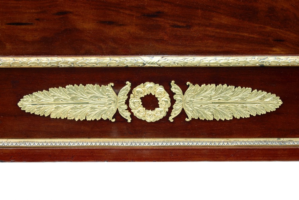 A five-piece nineteenth-century French Empire Revival mahogany bedroom suite featuring gilt bronze mounts, including a sleigh bed, a three-door mirrored wardrobe, a dressing table with mirror, and two matching bedside cabinets. View X