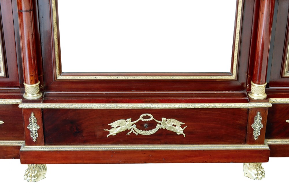 A five-piece nineteenth-century French Empire Revival mahogany bedroom suite featuring gilt bronze mounts, including a sleigh bed, a three-door mirrored wardrobe, a dressing table with mirror, and two matching bedside cabinets. View XIV