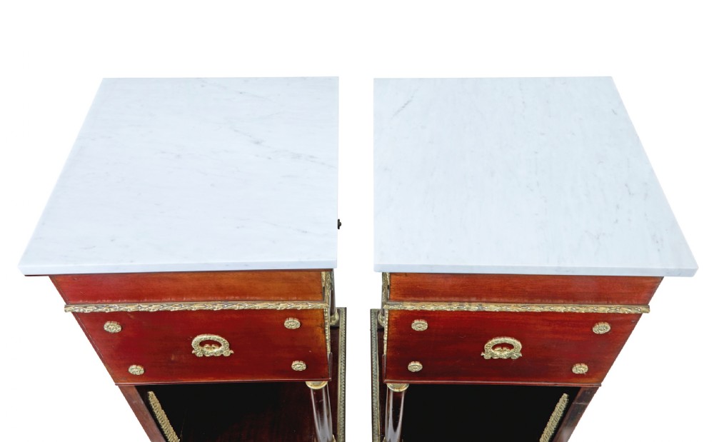 A five-piece nineteenth-century French Empire Revival mahogany bedroom suite featuring gilt bronze mounts, including a sleigh bed, a three-door mirrored wardrobe, a dressing table with mirror, and two matching bedside cabinets. View XXVIII