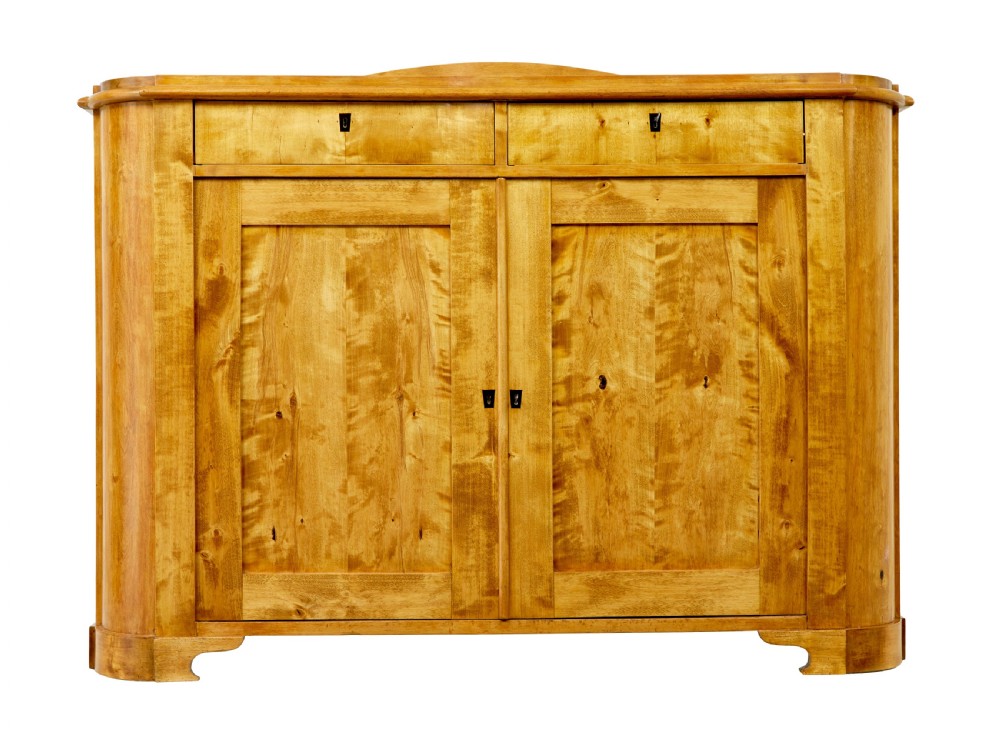 A mid-19th-century Swedish birch buffet sideboard featuring two top drawers, two cabinet doors, and curved side panels in a golden timber finish.