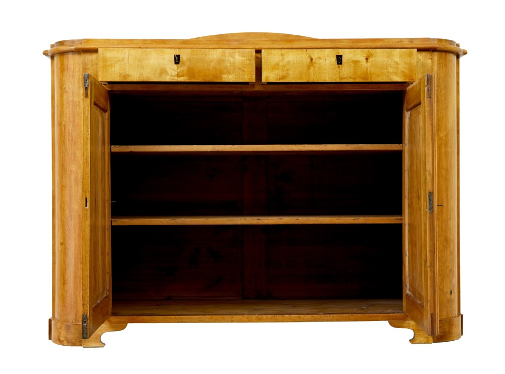A mid-19th-century Swedish birch buffet sideboard featuring two top drawers, two cabinet doors, and curved side panels in a golden timber finish. View II