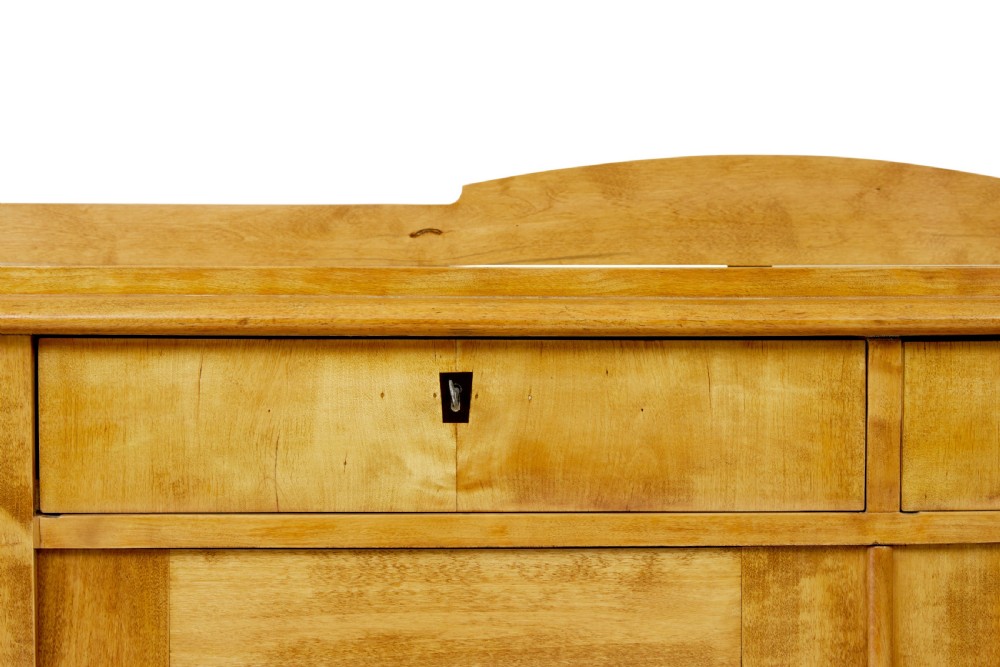 A mid-19th-century Swedish birch buffet sideboard featuring two top drawers, two cabinet doors, and curved side panels in a golden timber finish. View VIII