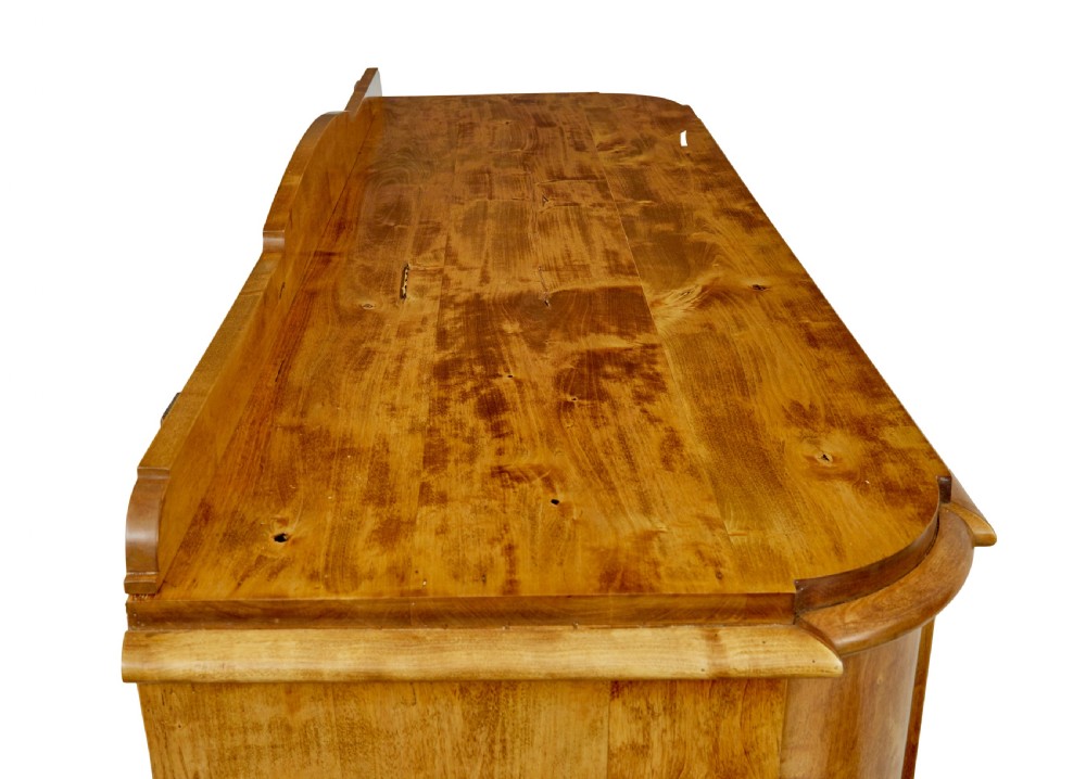 A mid-19th-century Swedish birch buffet sideboard featuring two top drawers, two cabinet doors, and curved side panels in a golden timber finish. View X