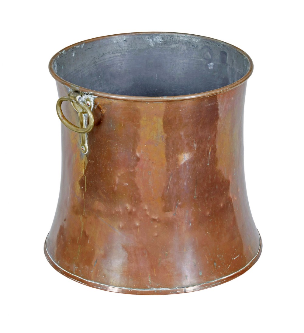 A 19th-century copper log bin featuring a flared, waisted silhouette, rolled rim, and cast brass ring handles.