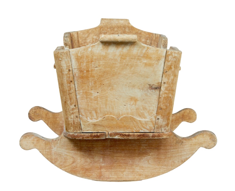 A mid-19th-century Swedish pine rocking cradle with hand-carved handles, scalloped edge detailing, and integrated wooden rockers. View III