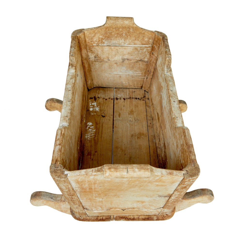A mid-19th-century Swedish pine rocking cradle with hand-carved handles, scalloped edge detailing, and integrated wooden rockers. View VIII