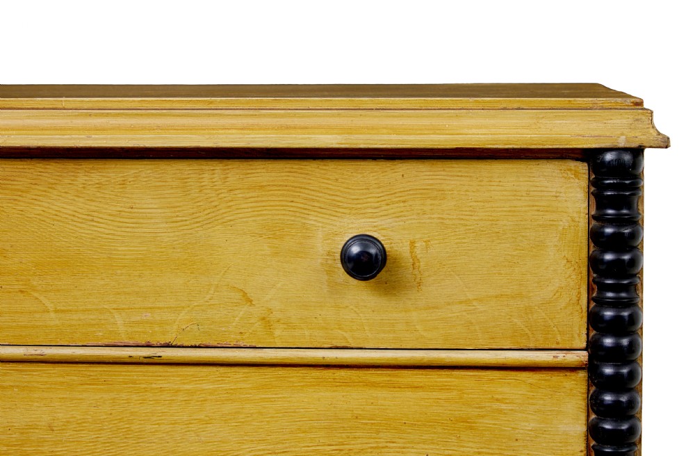 A mid-19th century Swedish northern pine chest of drawers featuring a yellow painted finish, four full-width drawers with black knobs, and black bobbin-turned corner columns. View VI