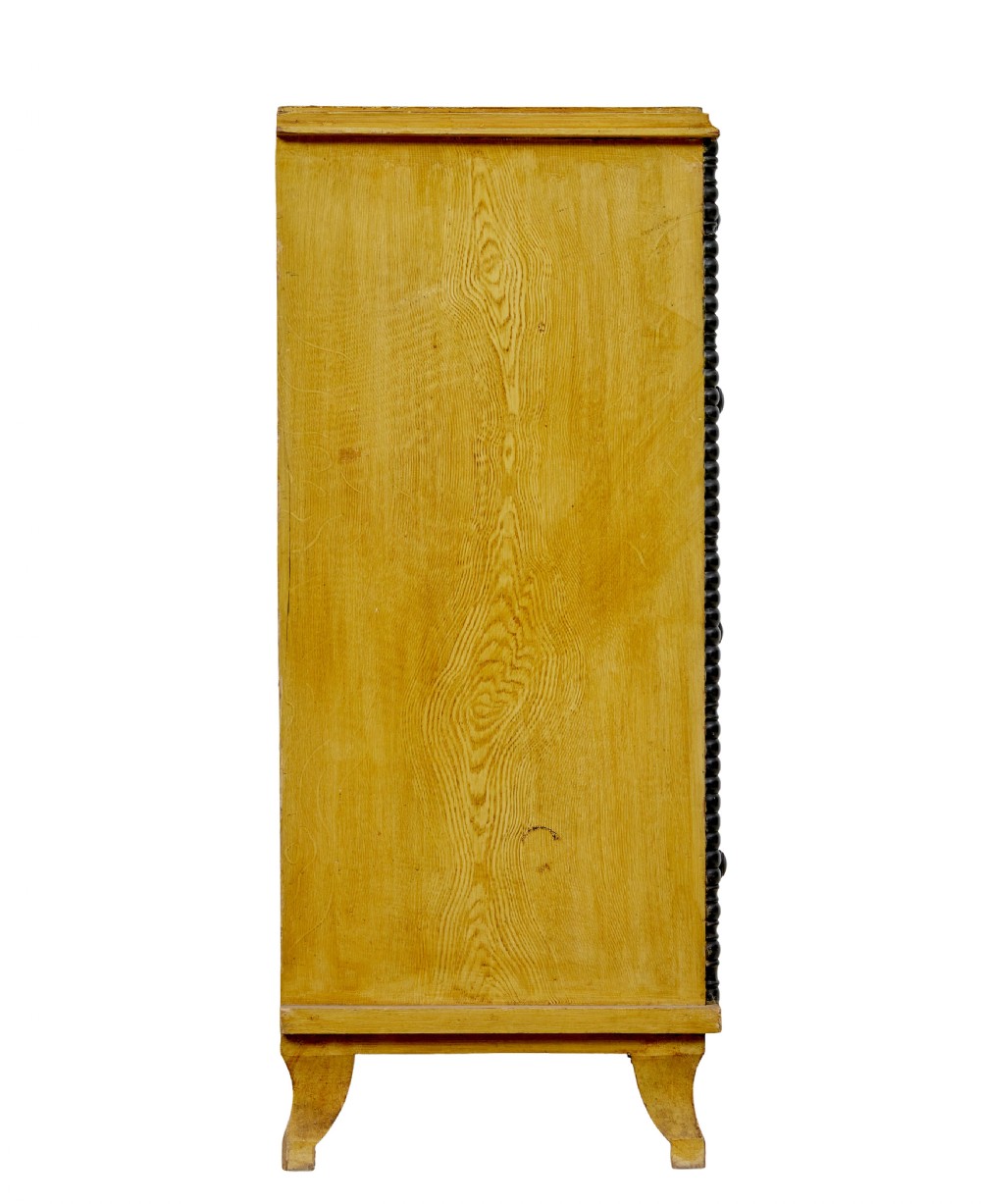 A mid-19th century Swedish northern pine chest of drawers featuring a yellow painted finish, four full-width drawers with black knobs, and black bobbin-turned corner columns. View XI