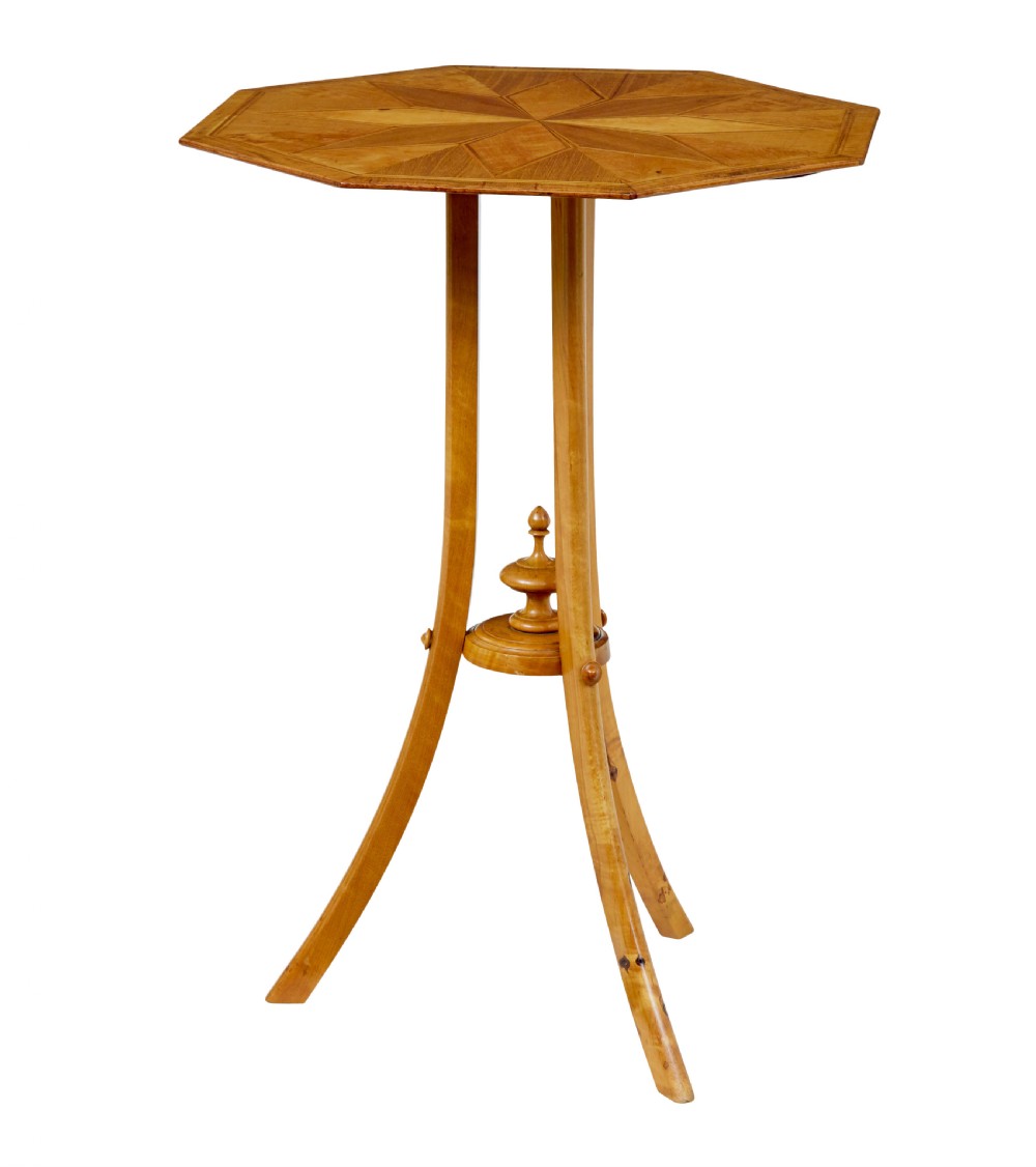 An early 20th-century octagonal occasional table made of light birch wood featuring a geometric starburst inlaid top and splayed legs. View III