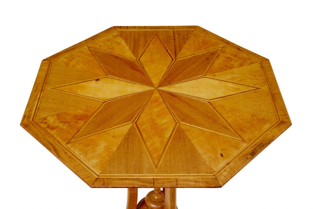 An early 20th-century octagonal occasional table made of light birch wood featuring a geometric starburst inlaid top and splayed legs. View IV