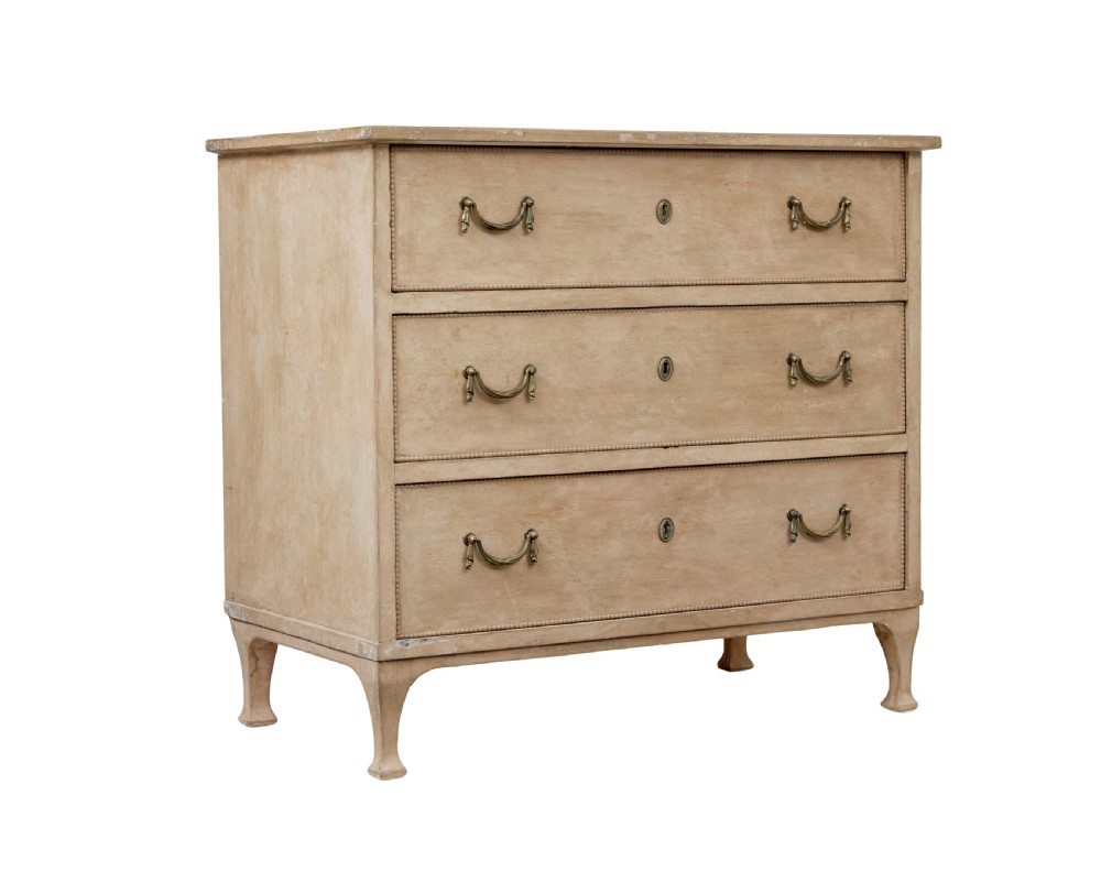 A nineteenth-century Swedish painted pine chest featuring three wide drawers with brass handles and a pale beige paint finish.