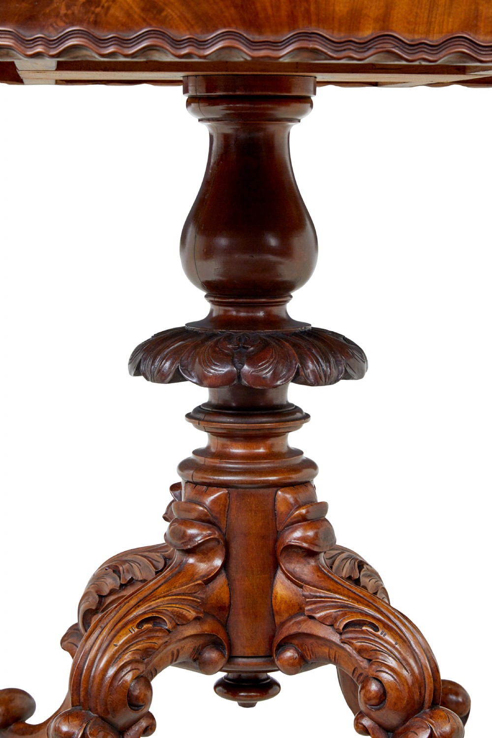 A 19th-century mahogany oval centre table featuring a flame mahogany veneered top, a scalloped apron, and a heavily carved tripod pedestal base with scroll feet. View III