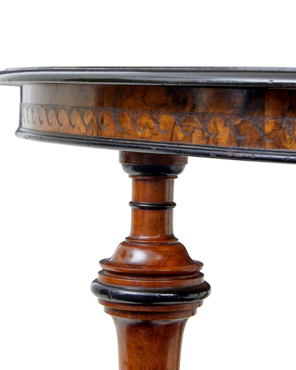 An early 20th-century circular burr walnut occasional table featuring an inlaid top, decorative apron, and three turned legs connected to a central carved triform base. View IX
