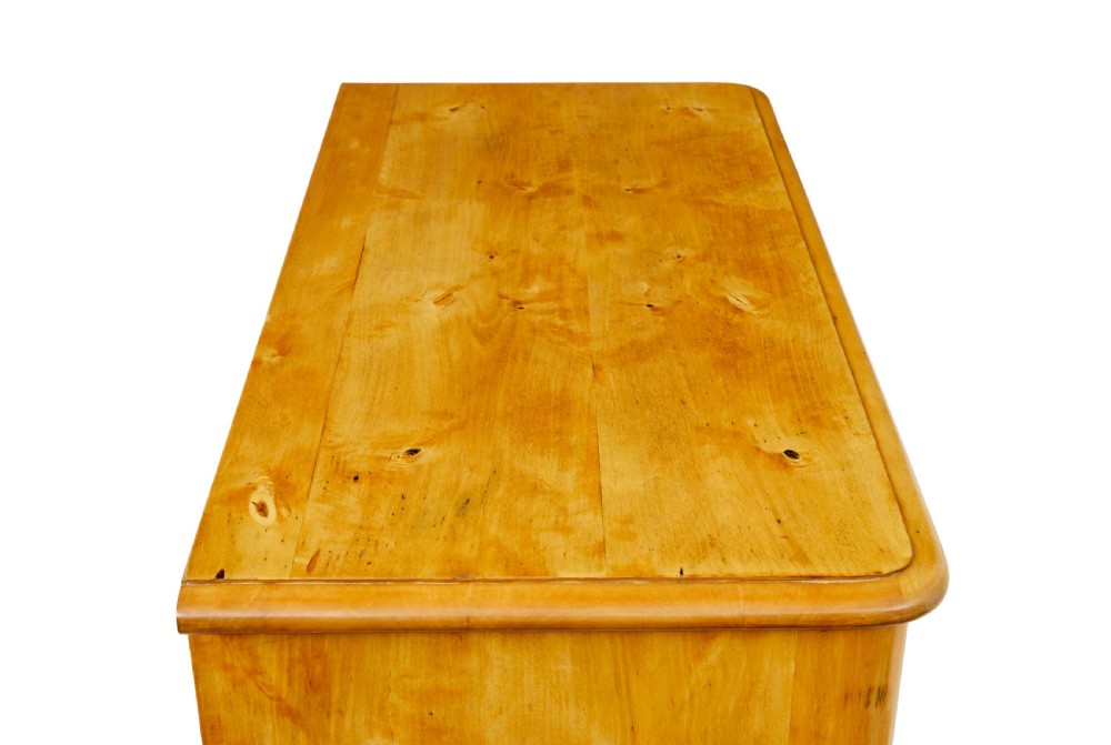 A mid-19th century Swedish birch chest of drawers featuring three full-width drawers with flame grain veneer and rounded side pilasters. View IX
