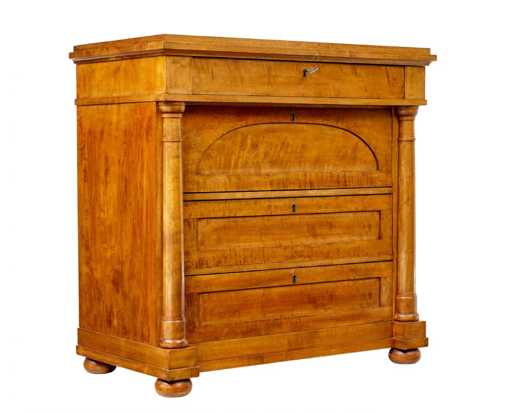 A 19th-century birch Empire Revival chest of drawers featuring architectural side columns, recessed panelled drawers, and turned bun feet.