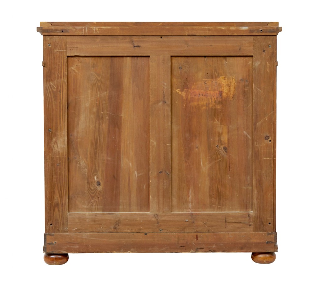 A 19th-century birch Empire Revival chest of drawers featuring architectural side columns, recessed panelled drawers, and turned bun feet. View VI