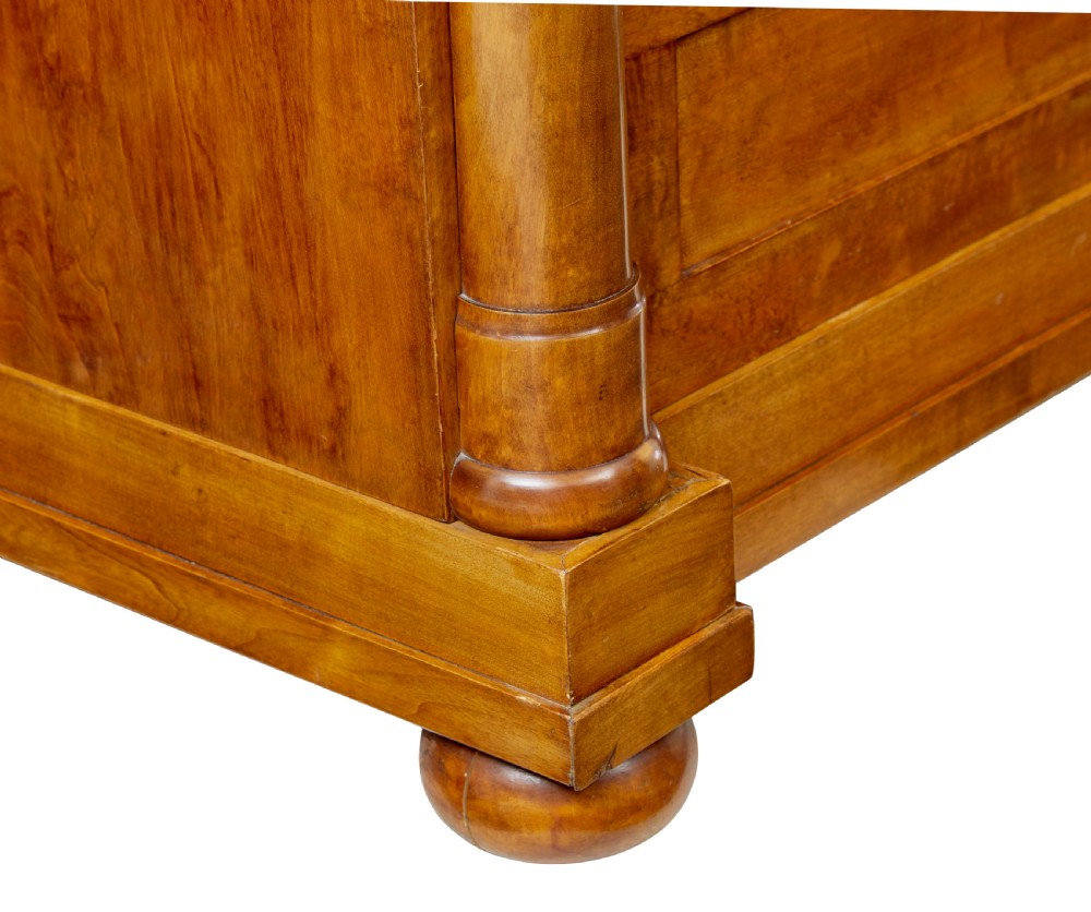 A 19th-century birch Empire Revival chest of drawers featuring architectural side columns, recessed panelled drawers, and turned bun feet. View VIII