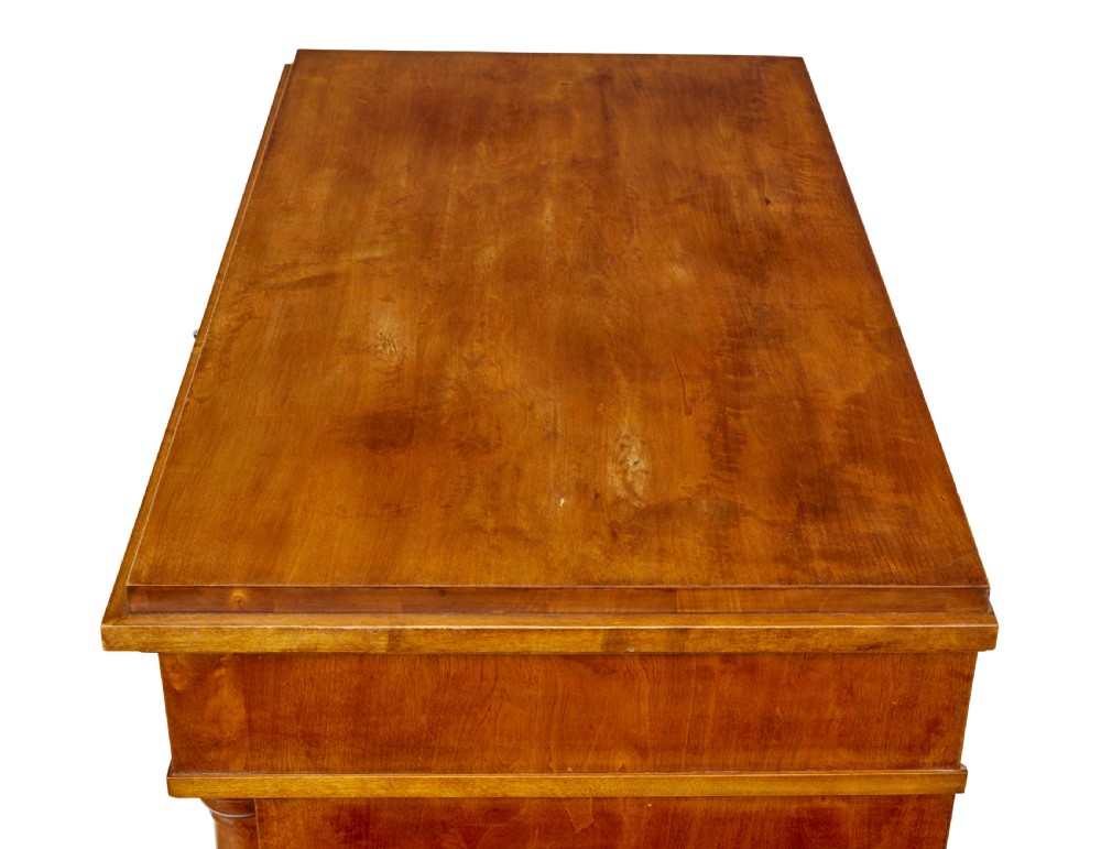 A 19th-century birch Empire Revival chest of drawers featuring architectural side columns, recessed panelled drawers, and turned bun feet. View X