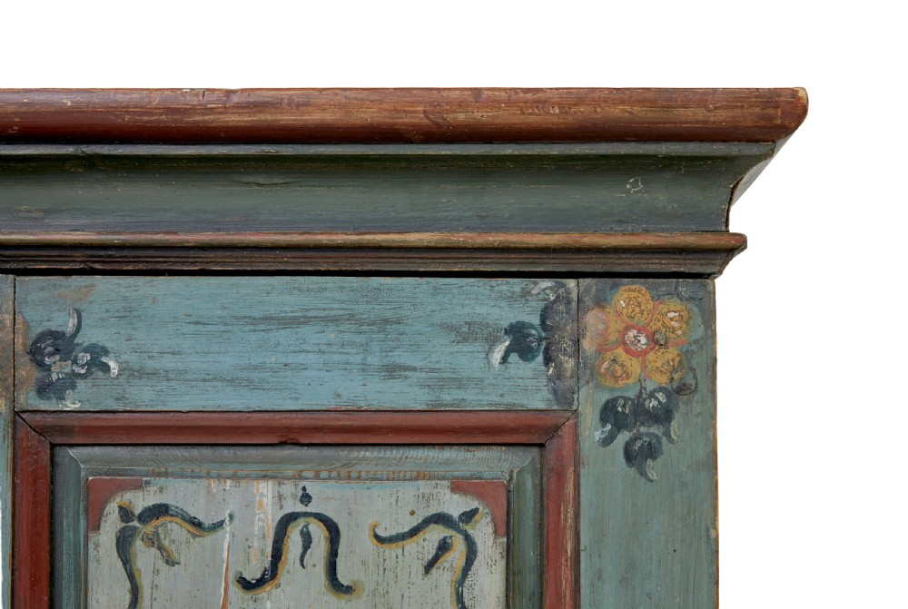 A Swedish hand-painted blue pine cupboard with panelled doors featuring floral motifs, red trim, a dated inscription from 1788, and bun feet. View IX