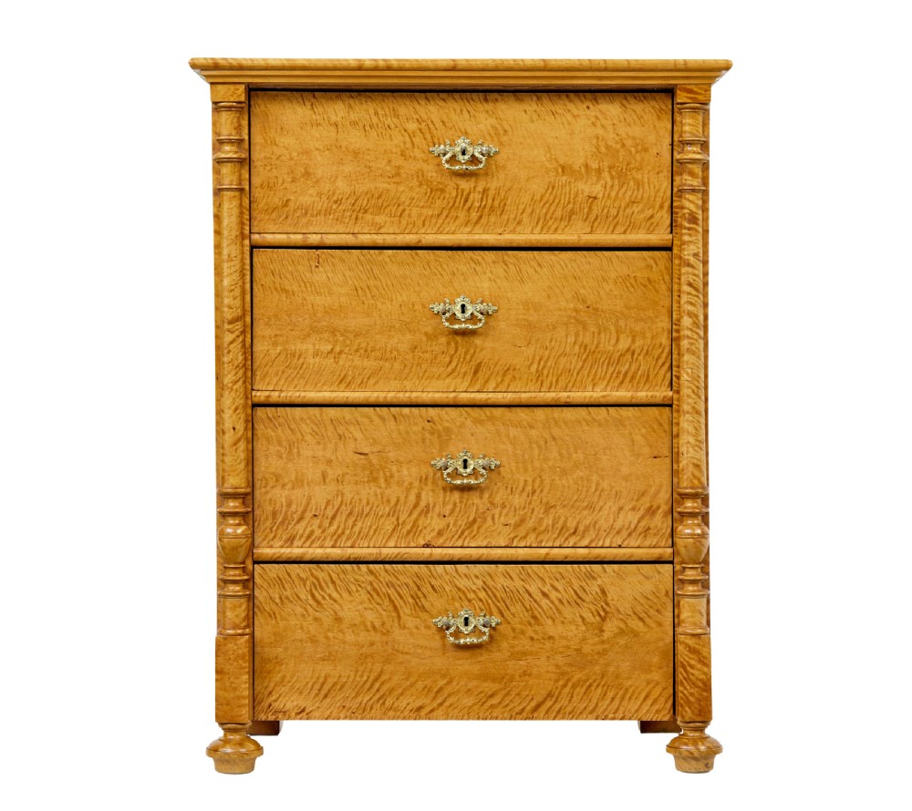 A nineteenth-century Swedish chest of four drawers crafted from figure-rich tiger birch with turned side columns and ornate brass escutcheons. View II