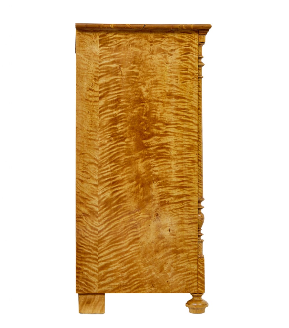 A nineteenth-century Swedish chest of four drawers crafted from figure-rich tiger birch with turned side columns and ornate brass escutcheons. View VII