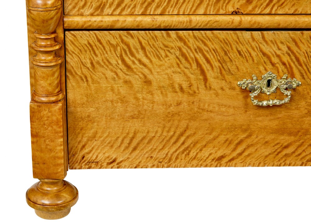 A nineteenth-century Swedish chest of four drawers crafted from figure-rich tiger birch with turned side columns and ornate brass escutcheons. View VIII