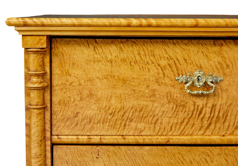 A nineteenth-century Swedish chest of four drawers crafted from figure-rich tiger birch with turned side columns and ornate brass escutcheons. View IX