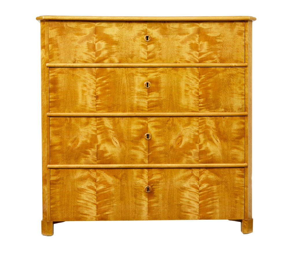 A 19th-century Swedish chest of four drawers crafted from golden flame birch veneer with simple keyhole escutcheons and square legs. View II