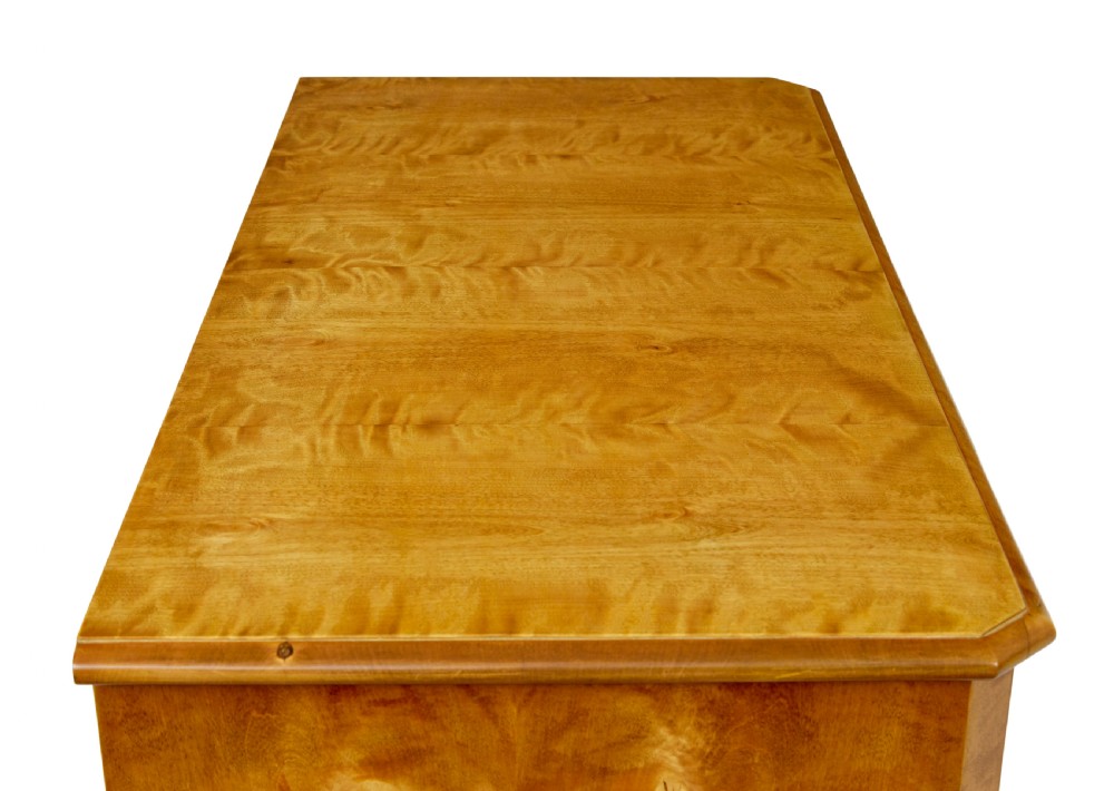 A 19th-century Swedish chest of four drawers crafted from golden flame birch veneer with simple keyhole escutcheons and square legs. View VIII