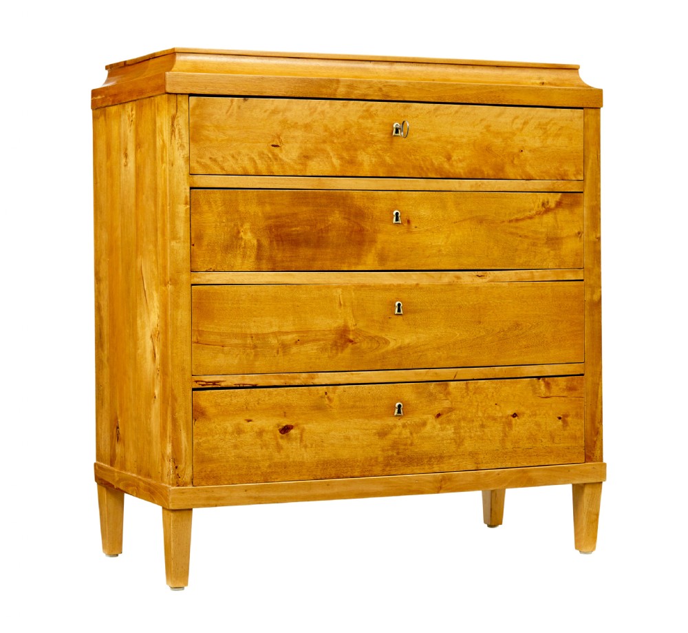 A 19th-century Swedish birch chest featuring four drawers with brass escutcheons, a stepped caddy top moulding, and tapered square legs.