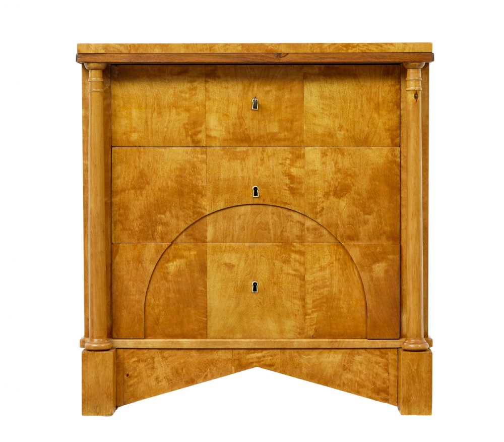 A 19th-century Swedish Empire satin birch chest of drawers featuring three drawers, flanking turned columns, an arched lower veneer panel, and angular block feet. View II