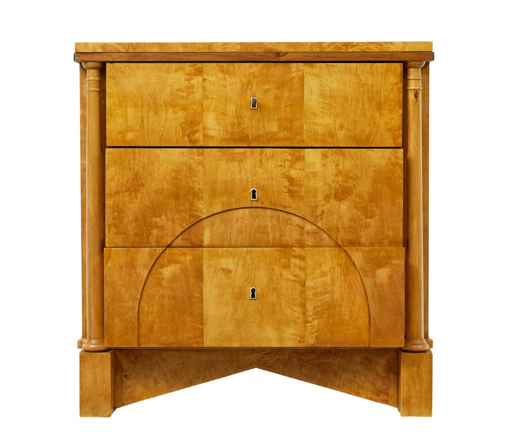 A 19th-century Swedish Empire satin birch chest of drawers featuring three drawers, flanking turned columns, an arched lower veneer panel, and angular block feet. View III