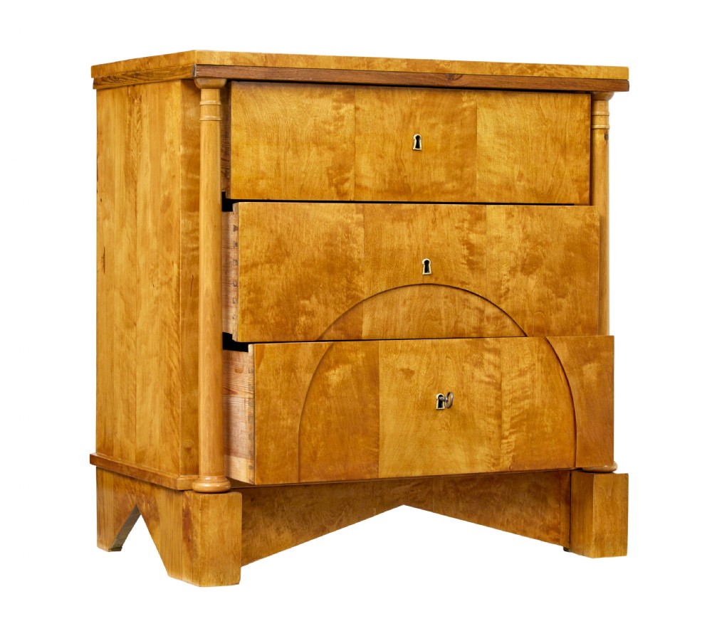 A 19th-century Swedish Empire satin birch chest of drawers featuring three drawers, flanking turned columns, an arched lower veneer panel, and angular block feet. View VIII
