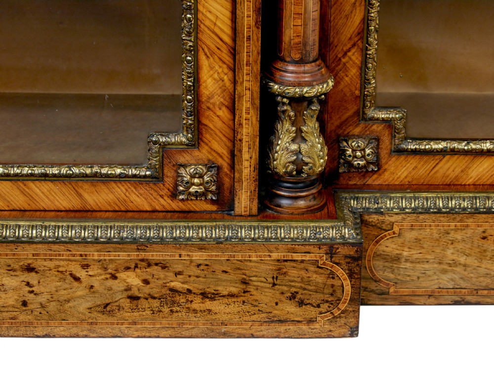 A mid-19th century Victorian walnut credenza featuring three glass-fronted doors, intricate marquetry inlay, and ornate gilt-bronze mounts. View X