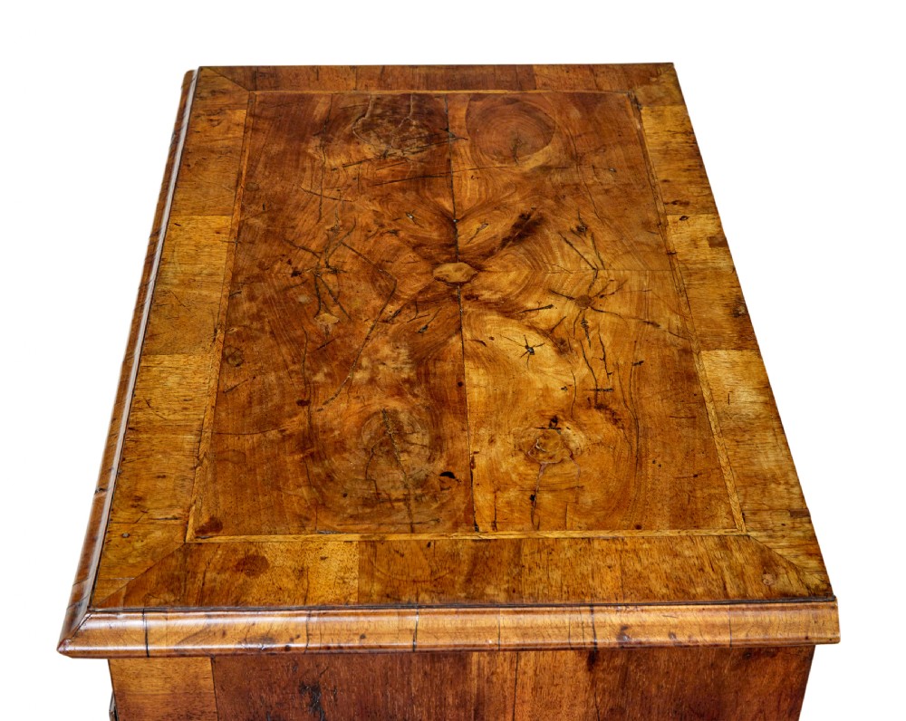 An eighteenth-century Queen Anne walnut kneehole desk featuring figured walnut veneers, brass drop handles, a central recessed cupboard, and bracket feet. View III
