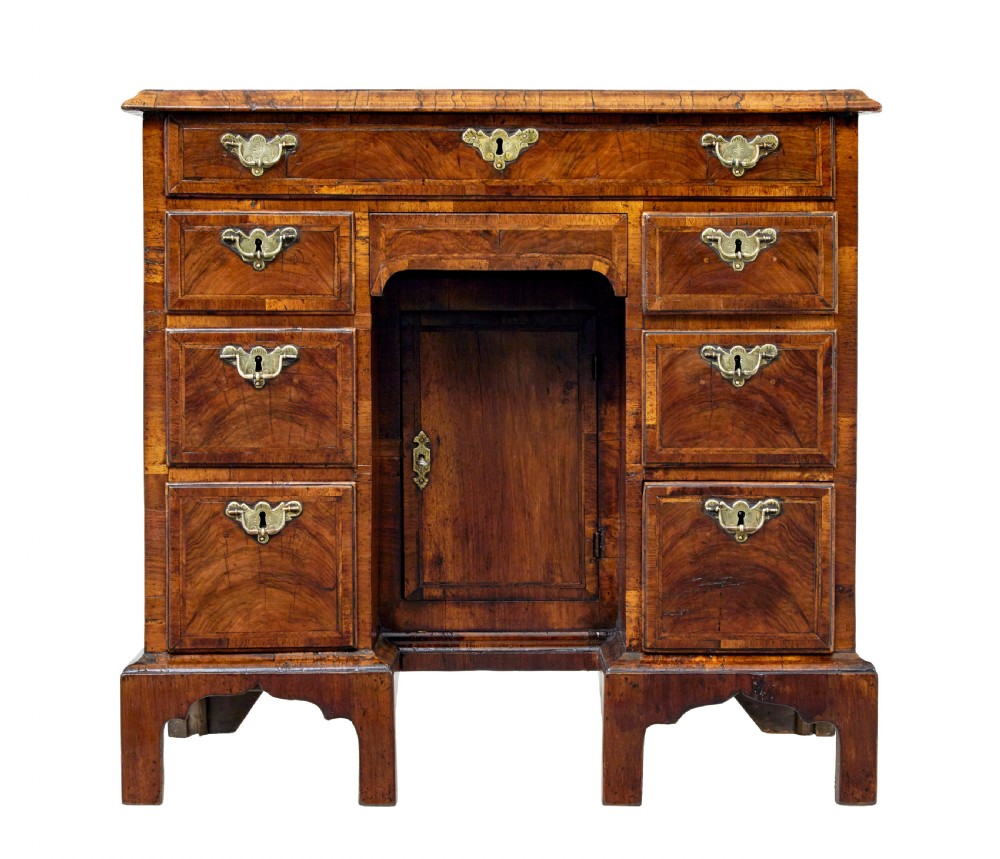 An eighteenth-century Queen Anne walnut kneehole desk featuring figured walnut veneers, brass drop handles, a central recessed cupboard, and bracket feet. View VIII