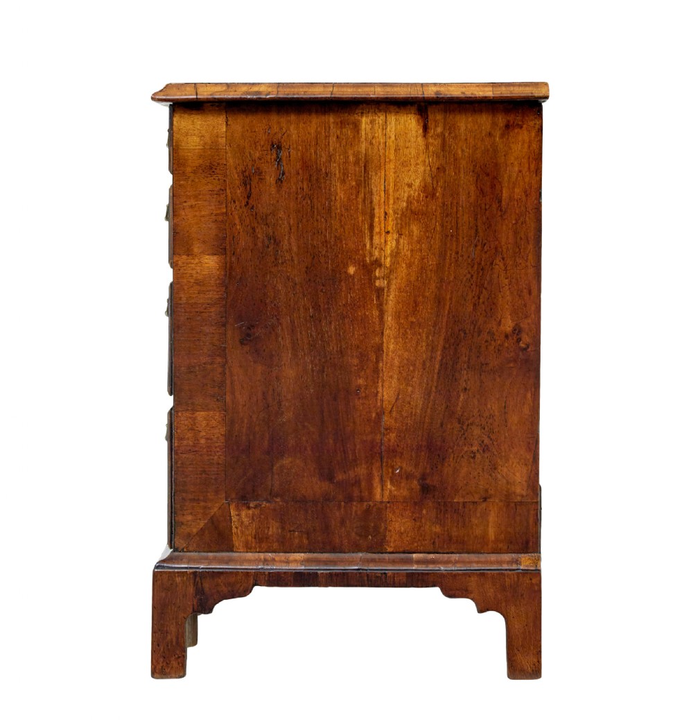 An eighteenth-century Queen Anne walnut kneehole desk featuring figured walnut veneers, brass drop handles, a central recessed cupboard, and bracket feet. View XII
