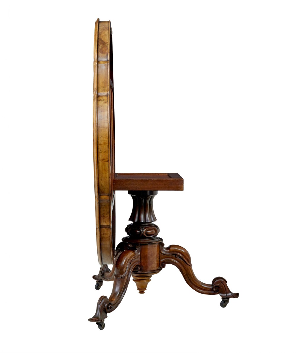 A 19th-century Victorian walnut centre table featuring intricate floral marquetry inlays, a shaped rim, and a carved central pedestal with four scroll legs on castors. View V