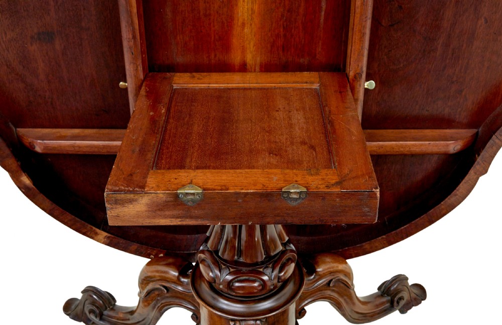 A 19th-century Victorian walnut centre table featuring intricate floral marquetry inlays, a shaped rim, and a carved central pedestal with four scroll legs on castors. View VII