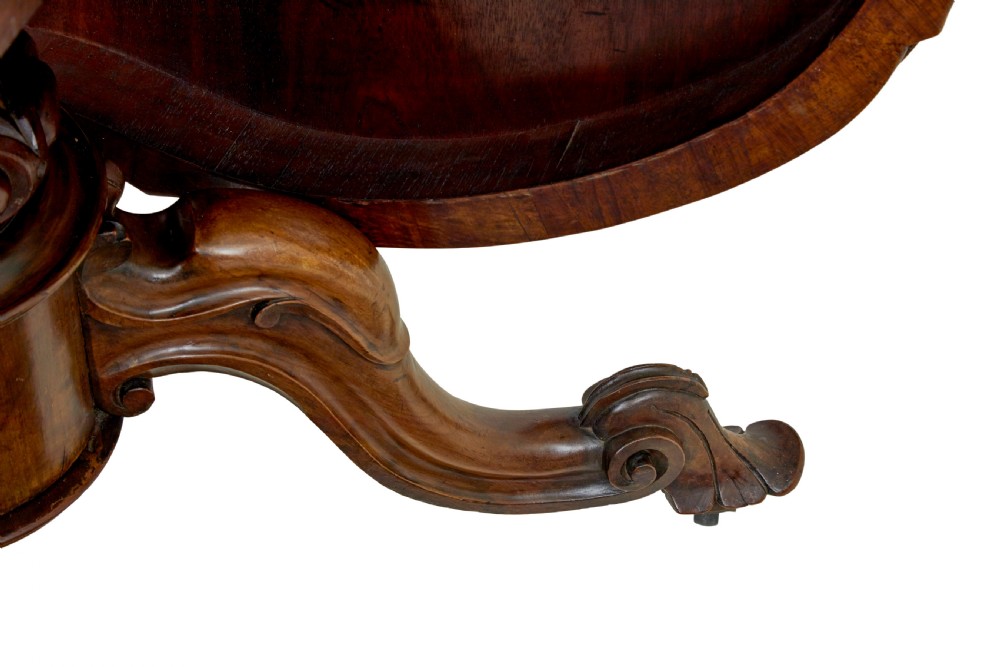 A 19th-century Victorian walnut centre table featuring intricate floral marquetry inlays, a shaped rim, and a carved central pedestal with four scroll legs on castors. View VIII